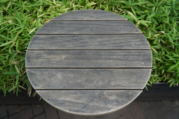 Empty of wood table top on fresh green grasses abstract background with tilt shifting focus. For...
