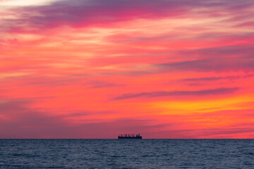 Naklejka na ściany i meble Horizon's Edge: Minimalistic Sunrise Seascape with a Ship