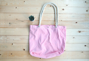 Empty pink cloth bag on wooden floor,