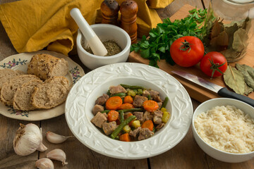 Plato de carne guisado con verduras y bol de arroz
