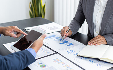 Asian business men and women are brainstorming and analyzing corporate financial graph data in the office.