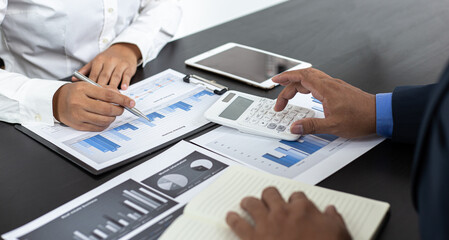 Asian business men and women are brainstorming and analyzing corporate financial graph data in the office.