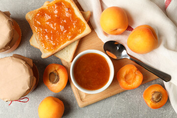 Composition with apricot jam on gray background, top view