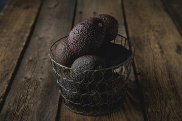 Hass avocado in a basket on a wooden table