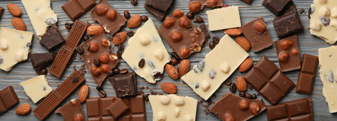 Different chocolate on gray wooden background, top view
