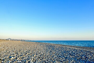 sea coast with pebble beach and city