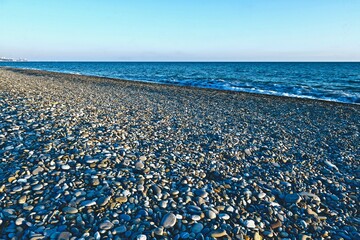 sea coast with pebble beach and city
