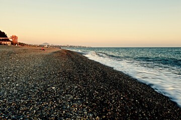 sea coast with pebble beach and city