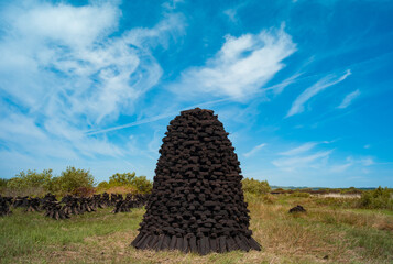 Pile of peat bog turf stacked up in field in rural county Kerry, Ireland, Scenic Irish landscape