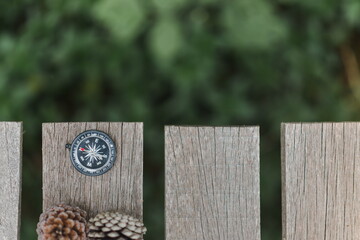 a compass on the wooden plate in the forest