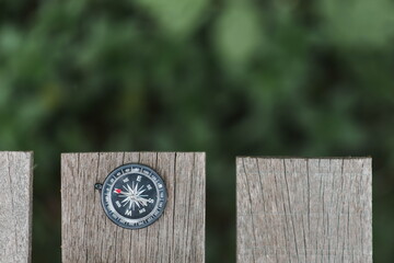 a compass on the wooden plate in the forest