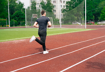 A male athlete runs on sports red treadmill. The concept of a healthy lifestyle