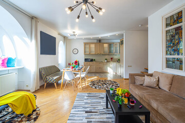 Modern interior of living area and kitchen in studio apartment. Private house. Set table. Kitchen set. Cozy furniture.