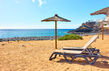 Beach with parasol and sunbeds by the sea © Roman Sigaev