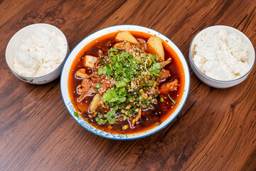 MaoCai sichuan food dish in a bowl on a table with two rice portions