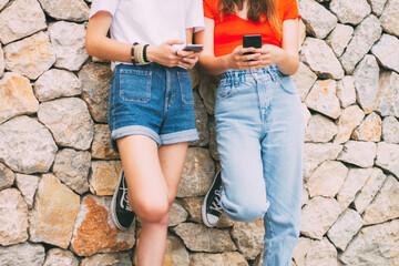 two teenagers of z or millennial generation using street telephones, concept of influence and use...