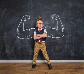 Portrait of smart kid boy with drawn muscles. Success, creative and innovation business concept