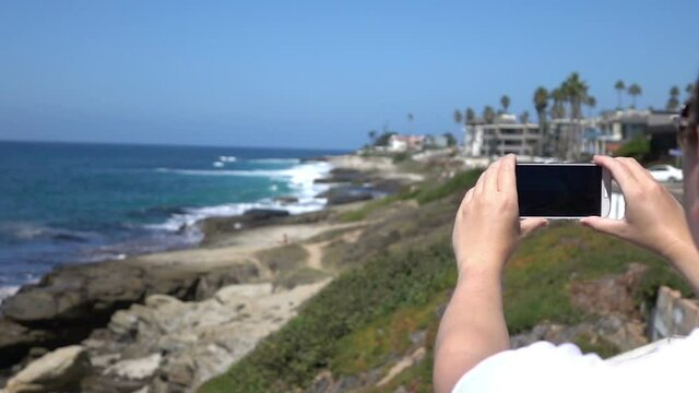 Woman making video of oceanside in California in slow motion 250fps