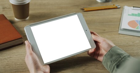 Close up of woman hands holding digital tablet with blank screen.