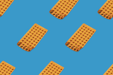 Orange pill blister pattern on a blue background