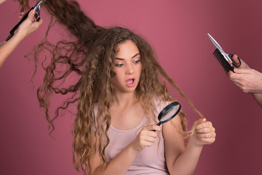 Hair dresser concept, beautiful young woman with long curly hair, hands around head, holding scissors, comb, iron, magnifier