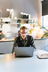 Young Man Freelancer Using Laptop Online Working From Office In Internet, Smiling Focused Millennial Guy Searching On Computer Surfing Web Looking At Screen Enjoying Distant Job