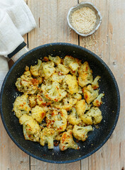Roasted cauliflower with olive oil, sesame seed, dill and spices. Tasty snack. Vegetarian dish. Rustic style. Selective focus