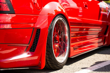 Red sports tuned car rear view of the wheel, close-up .
