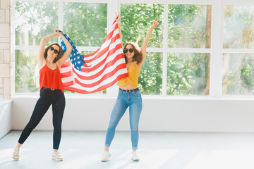 Two attractive young girls in sunglasses with the American flag, U.S.A independence day celebrations