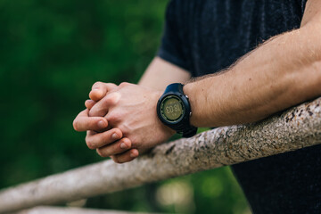 sporty man hands closeup outdoors using a fitness heart-rate wat
