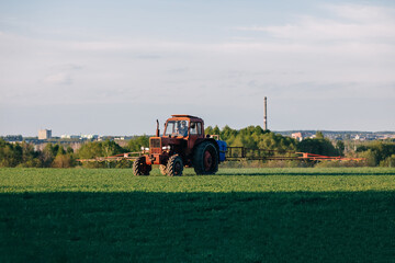 Obraz premium Tractor cultivating field at spring