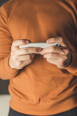 Fototapeta premium man using mobile phone with both hands