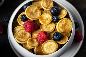 Food cooking trend, pancake cereal, tiny pancakes with raspberry, blueberry
