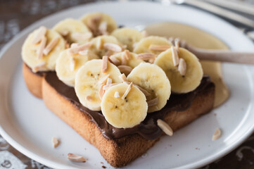 toasted bread topped with chocolate, banana, sliced almond and honey