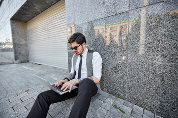 Young handsome man sitting and working on laptop