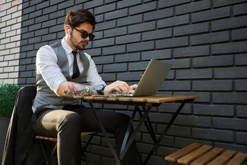 Young handsome man sitting and working on laptop