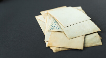 A stack of old photos lying on the table. Photo card rumpled and dirty vintage. Retro postcard. Memories of old times
