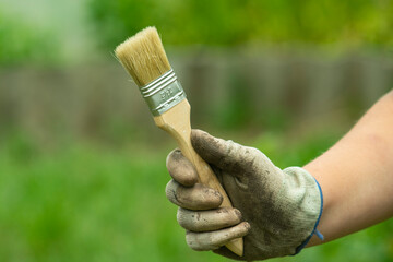 Paint brush in the hand of a worker.