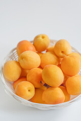 Sweet apricots in a plate on a white table.