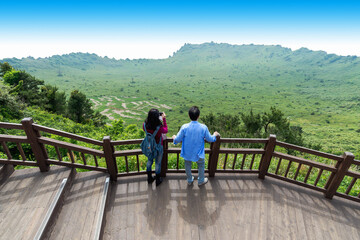 Fototapeta na wymiar Man and Women looking Crater View of Songsan Ilchulbong in jeju island.