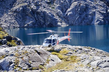 Running helicopter landed on rocks - lake in background on Mt. Kidd.