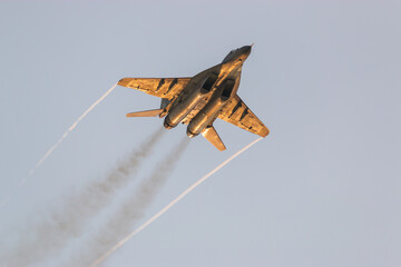 Jet fighter on display during an air show with smoke and vortices