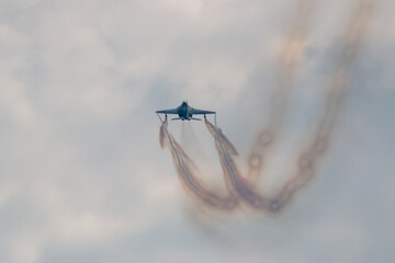 Jet aircraft during airshow aerobatic display with smoke