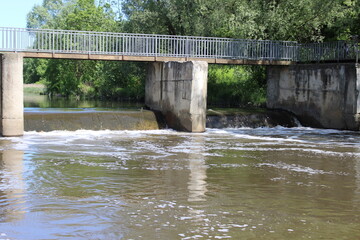 Obraz premium Old pedestrian bridge and a small dam. Moscow, Russia.