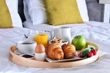 Breakfast on tray in bed in hotel room