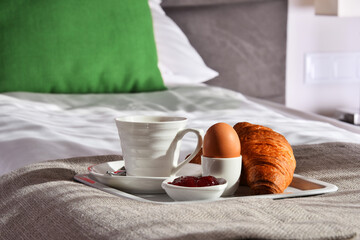 Breakfast on tray in bed in hotel room