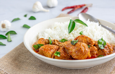 Chicken Kori Gassi, Spicy South Indian Chicken Curry with Rice Garnished with Curry Leaves in a Bowl Close Up Photo