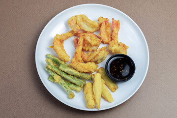 Batter fried shrimp in a white plate with dipping sauce