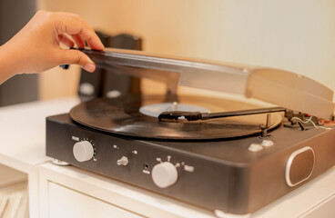 Female hand opening the  CD player machine's knob and put on the CD disc in to the machine,