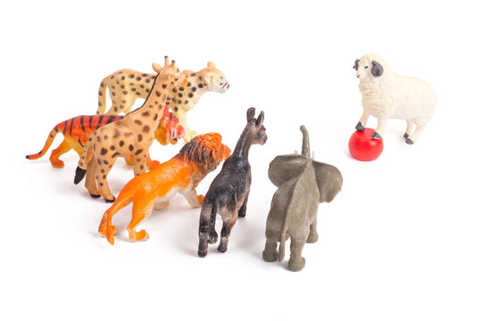 Toy plastic figurines of animals on white isolated background. One against all. Crowd of animals in front of their leader. Leadership concept. Speech to the people. Following the charismatic leader.